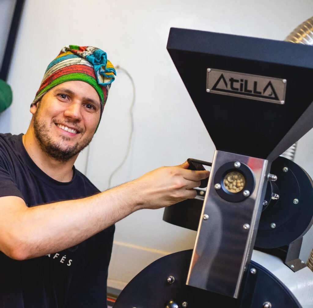 Pedro Anjos, barista e mestre de torra da Mokado Lab de Cafés, em frente a uma máquina de torra de café